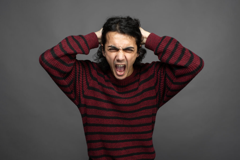 Как проявляется пассивная агрессия? a guy shouts while holding his head